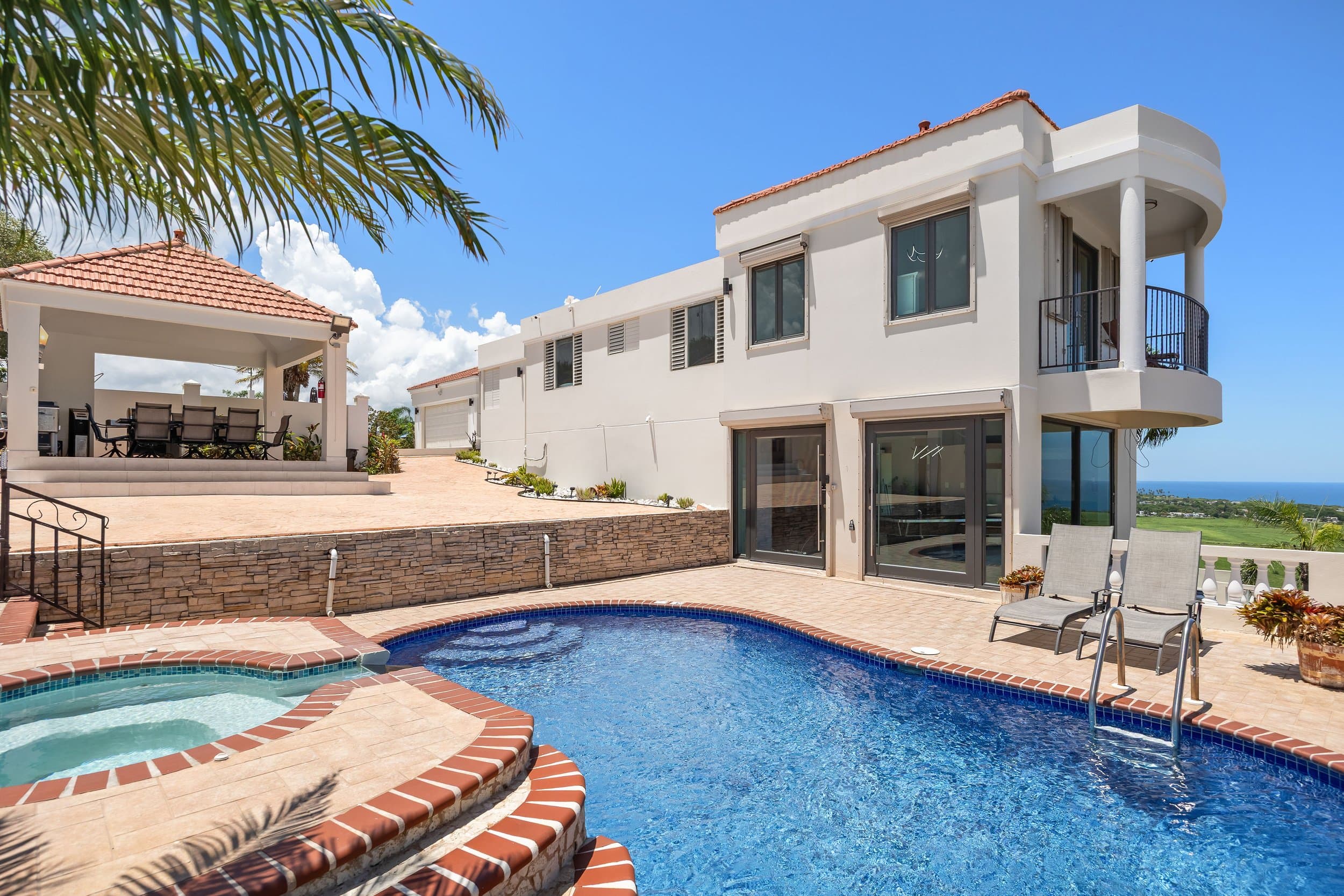 Pool terrace with loungers under palms